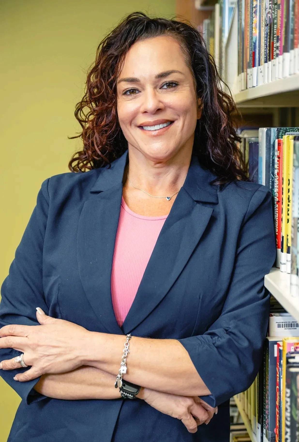 Smiling woman standing in a library.